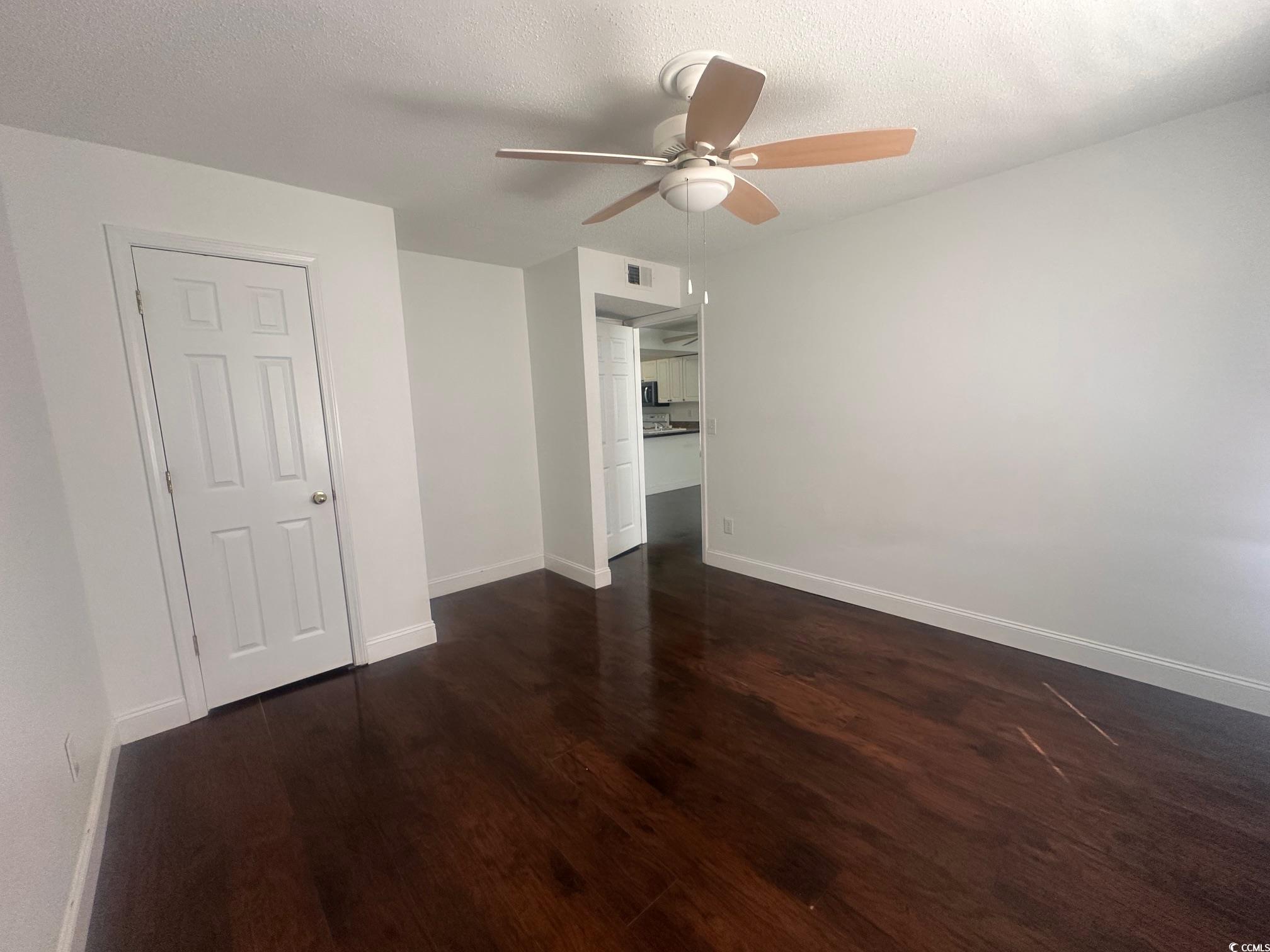 3555 Highway 544, Unit 27B Conway, SC 29526 - Photo 6 of 6 Empty room featuring dark wood-style flooring, a textured ceiling, and a ceiling fan
