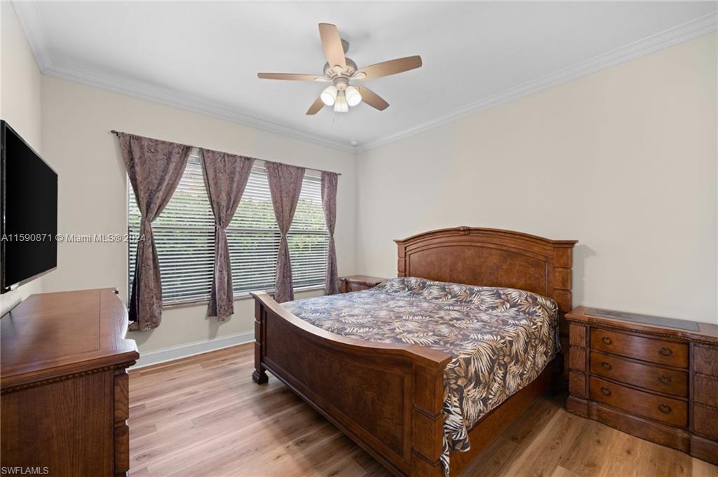 1276 Strada Milan Lane, Unit 2 Naples, FL 34105 - Photo 17 of 36 a bedroom with a bed and a flat screen tv