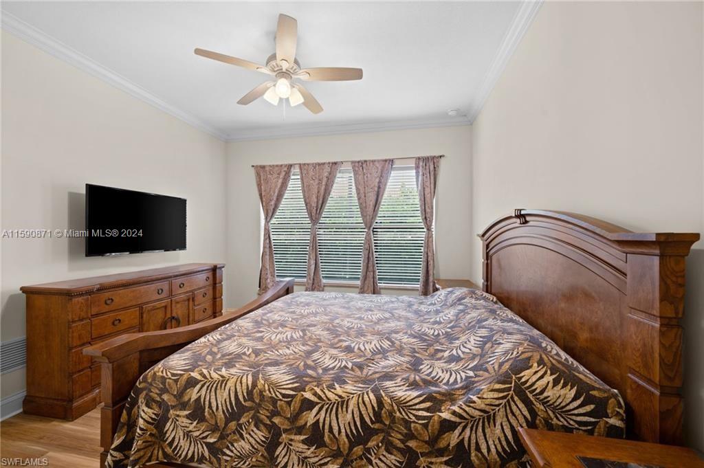 1276 Strada Milan Lane, Unit 2 Naples, FL 34105 - Photo 18 of 36 a bedroom with a bed and a flat screen tv