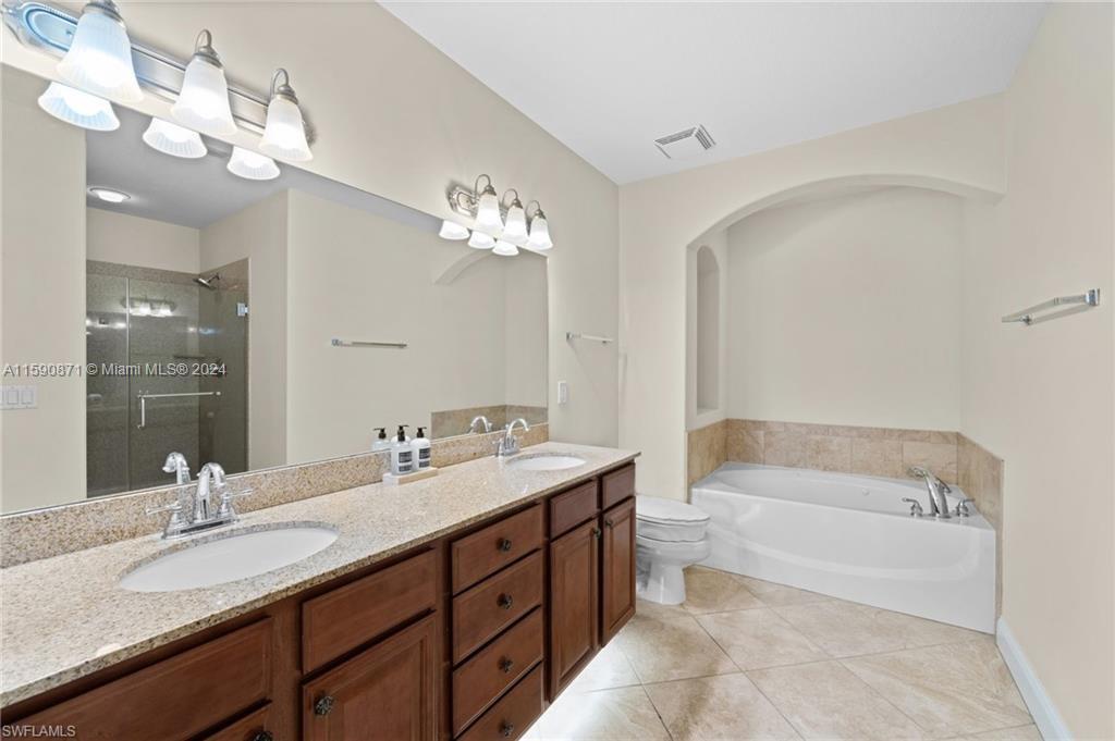 1276 Strada Milan Lane, Unit 2 Naples, FL 34105 - Photo 19 of 36 a bathroom with a tub double sink and mirror