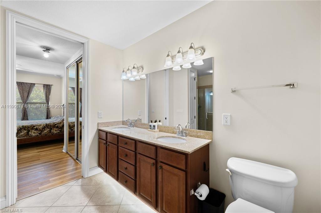 1276 Strada Milan Lane, Unit 2 Naples, FL 34105 - Photo 21 of 36 a spacious bathroom with a toilet sink and mirror