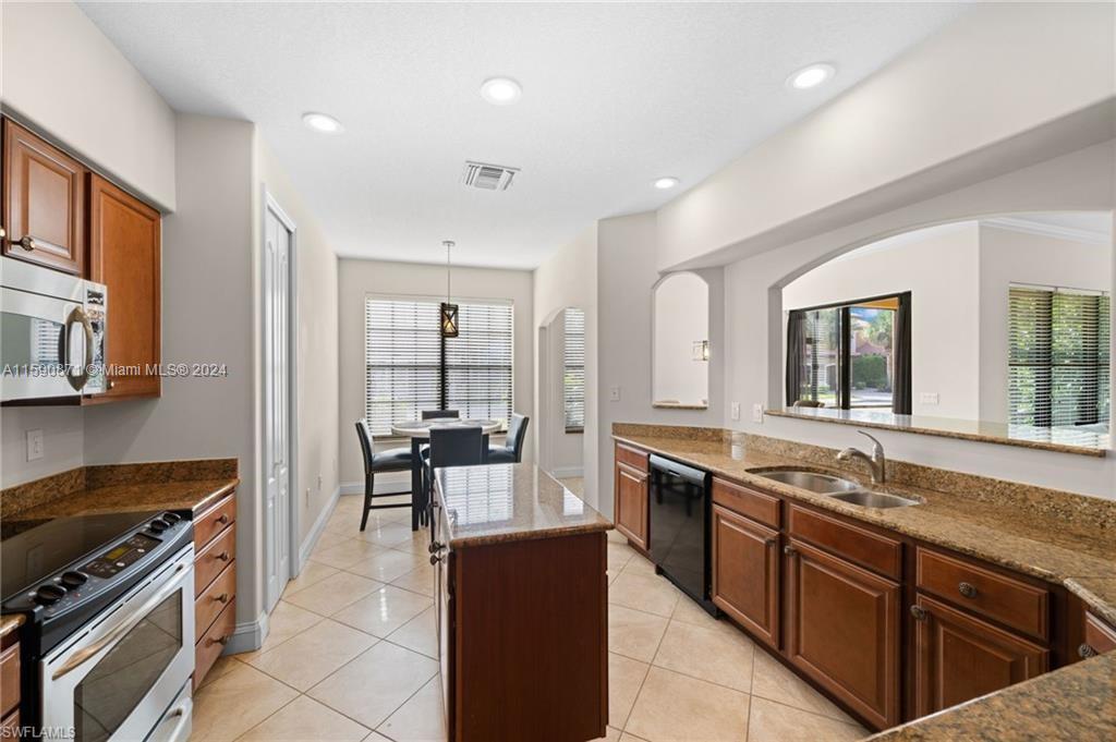 1276 Strada Milan Lane, Unit 2 Naples, FL 34105 - Photo 3 of 36 a large kitchen with stainless steel appliances granite countertop a stove and a sink