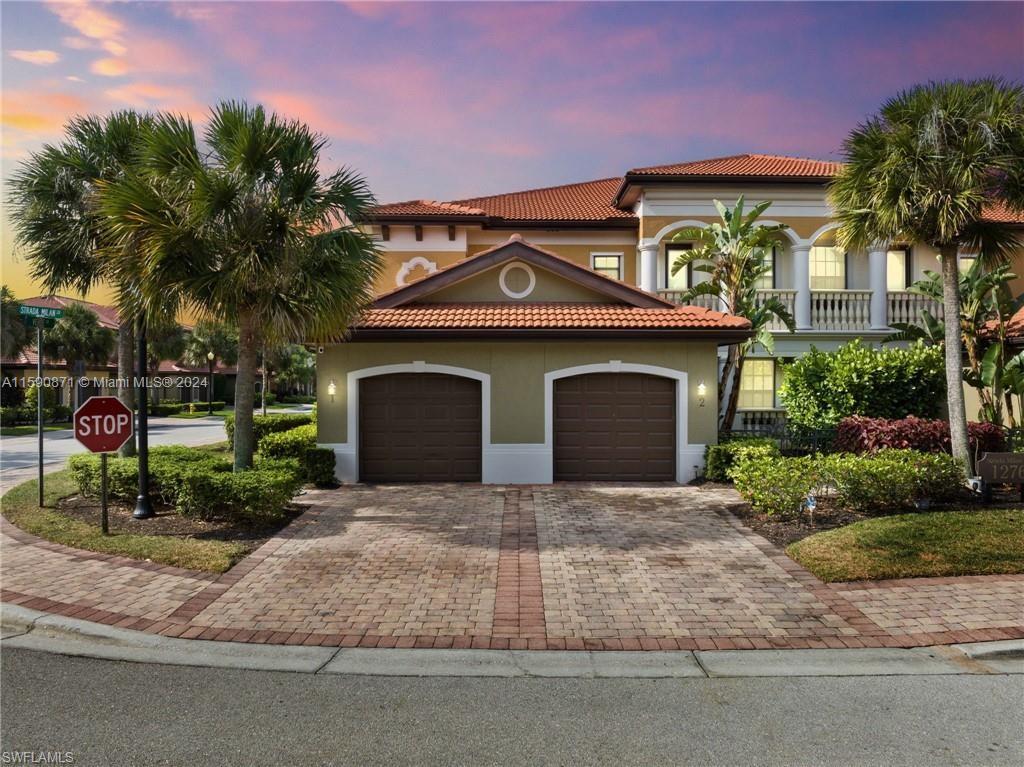 1276 Strada Milan Lane, Unit 2 Naples, FL 34105 - Photo 35 of 36 a front view of a house with a yard and garage