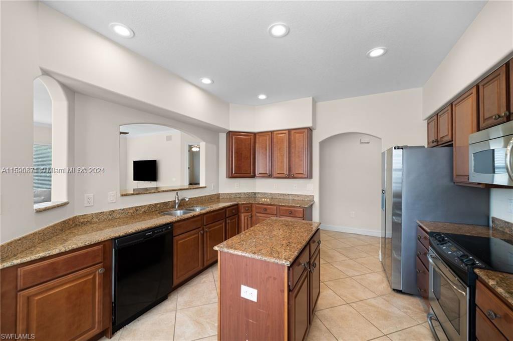 1276 Strada Milan Lane, Unit 2 Naples, FL 34105 - Photo 6 of 36 a kitchen that has a sink and a stove in it