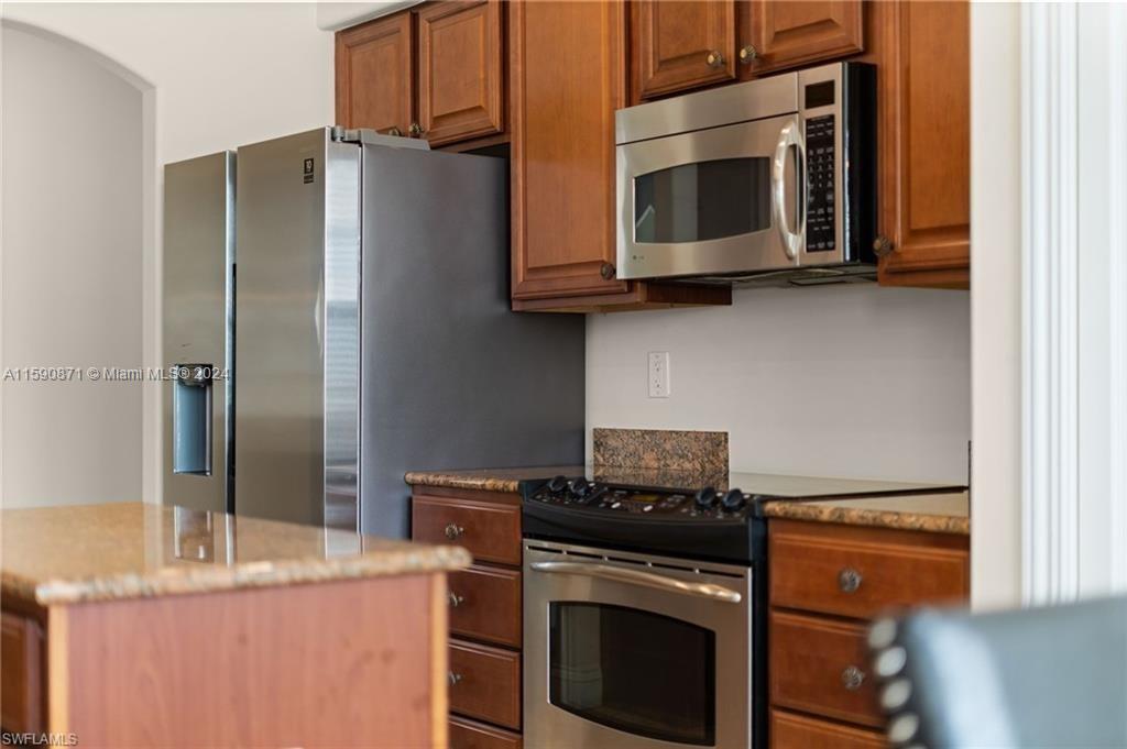 1276 Strada Milan Lane, Unit 2 Naples, FL 34105 - Photo 7 of 36 a kitchen with stainless steel appliances granite countertop a refrigerator stove and microwave