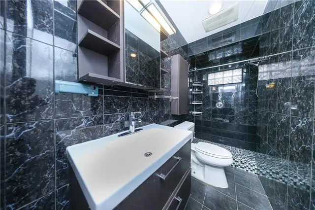 a bathroom with a sink a toilet and shower