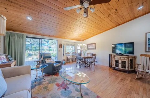 a living room with furniture a flat screen tv and a large window