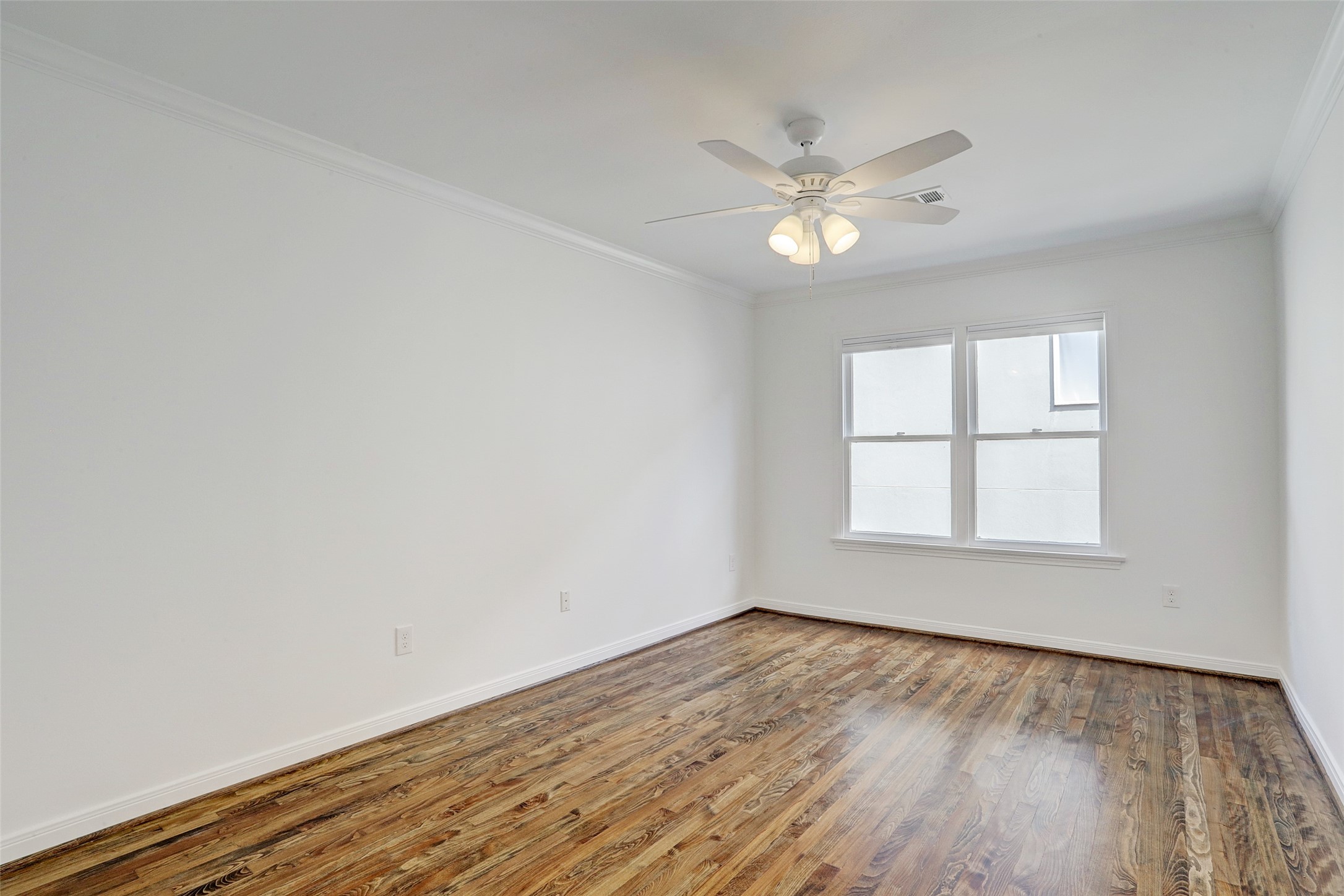 2011 South Boulevard Houston, TX 77098 - Photo 12 of 24 an empty room with wooden floor fan and windows