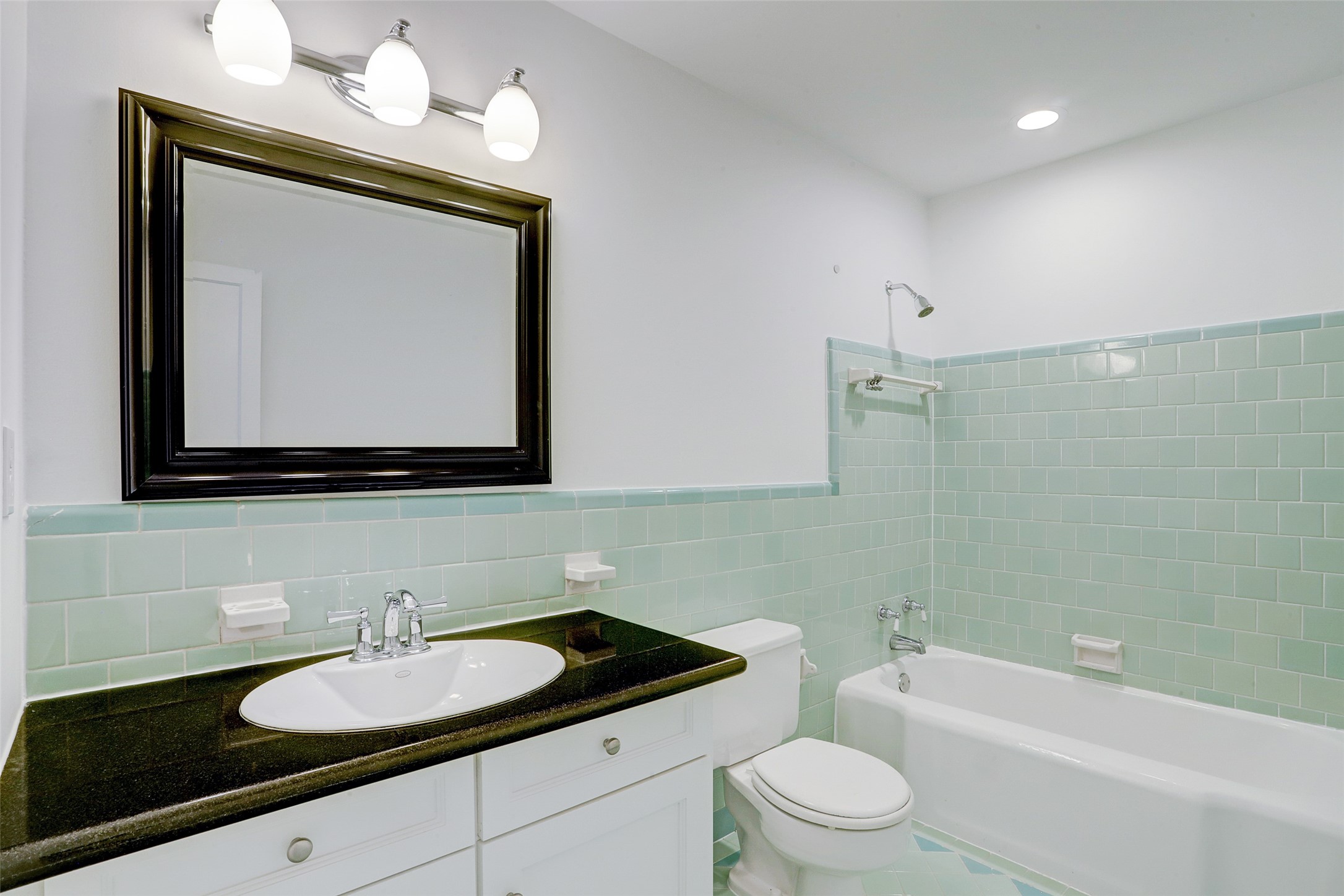 2011 South Boulevard Houston, TX 77098 - Photo 18 of 24 a bathroom with a granite countertop sink a toilet a mirror and bathtub