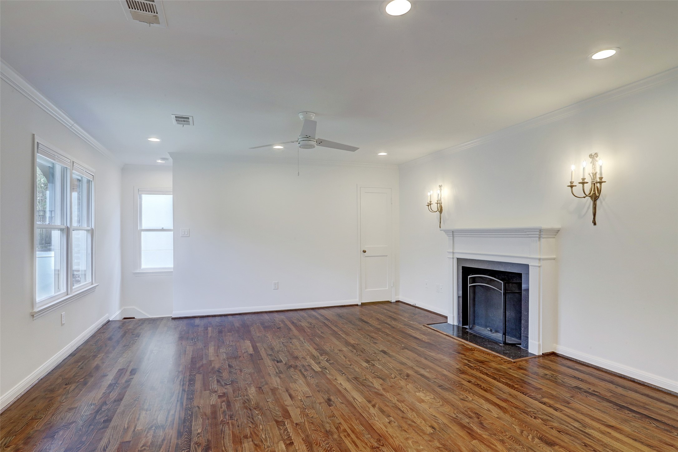 2011 South Boulevard Houston, TX 77098 - Photo 3 of 24 an empty room with wooden floor fireplace and windows