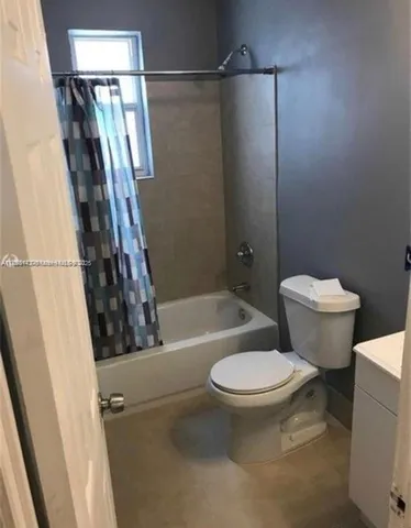 a white toilet sitting next to a bath tub