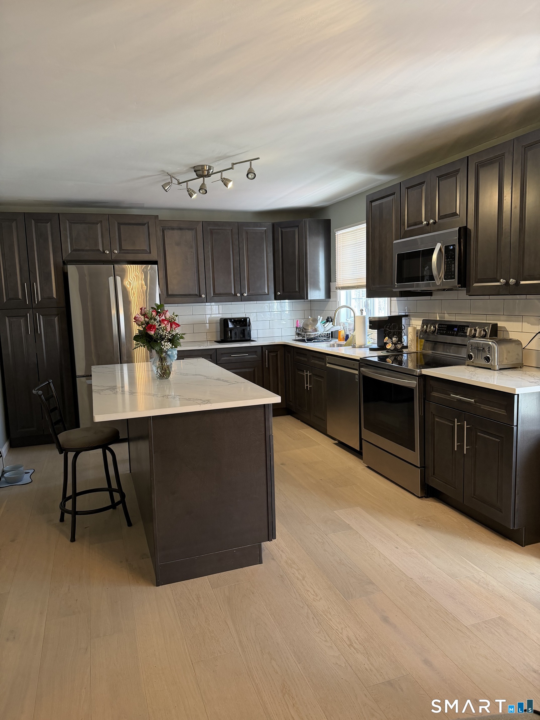61 Victoria Court Hamden, CT 06514 - Photo 10 of 10 a kitchen with kitchen island granite countertop a sink dishwasher stove and cabinets