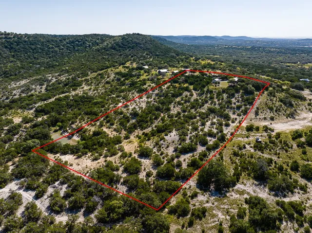 an aerial view of residential house with parking and yard