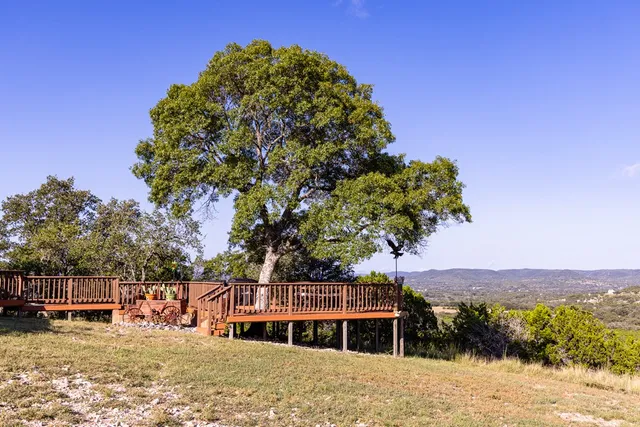 a view of balcony with wooden floor and trees