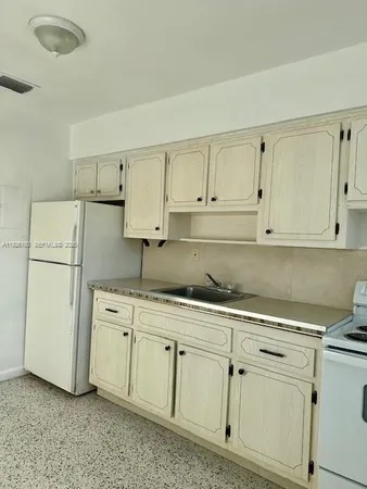 a kitchen with white cabinets and white appliances