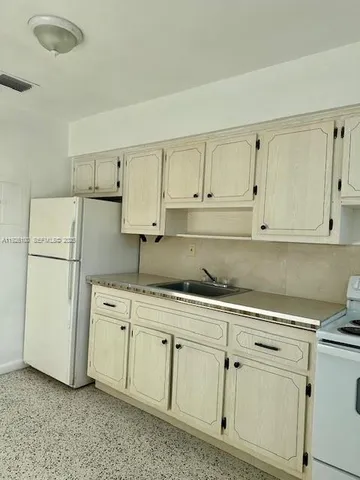 a kitchen with white cabinets and white appliances