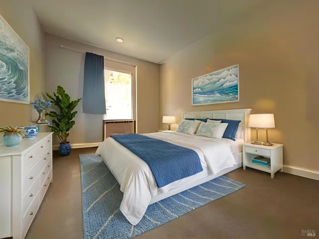 a spacious bedroom with a large bed and a potted plant