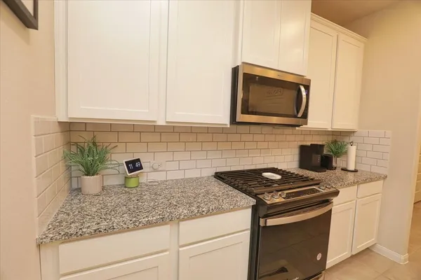 a kitchen with stainless steel appliances granite countertop a sink stove and microwave
