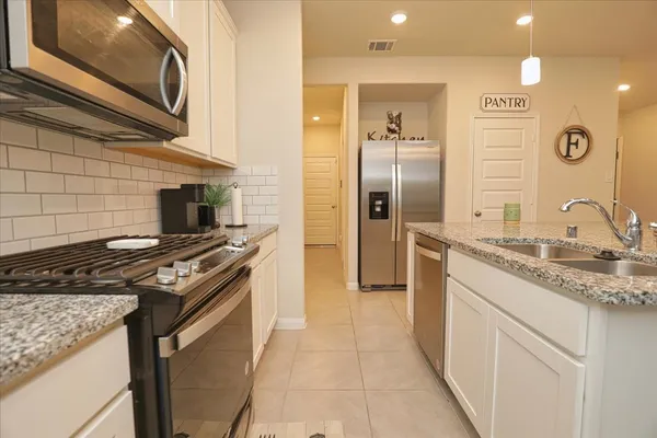 a kitchen with stainless steel appliances granite countertop a stove and a refrigerator