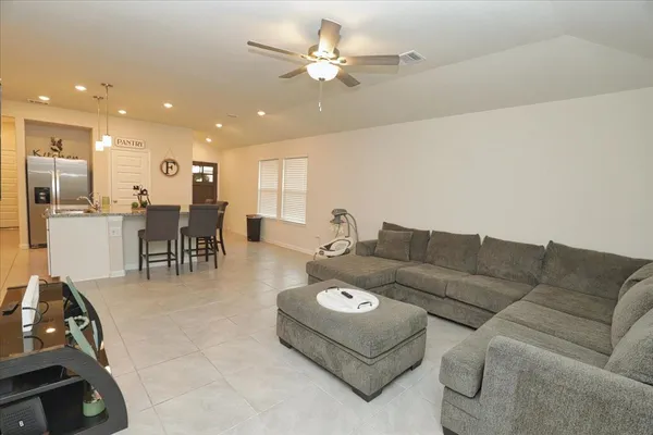 a living room with furniture and kitchen view
