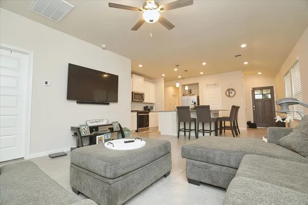 a living room with furniture kitchen view and a flat screen tv