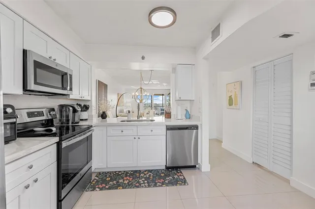 a kitchen with granite countertop a sink stove and microwave