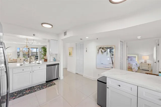 a large white kitchen with a stove a sink a window and a refrigerator