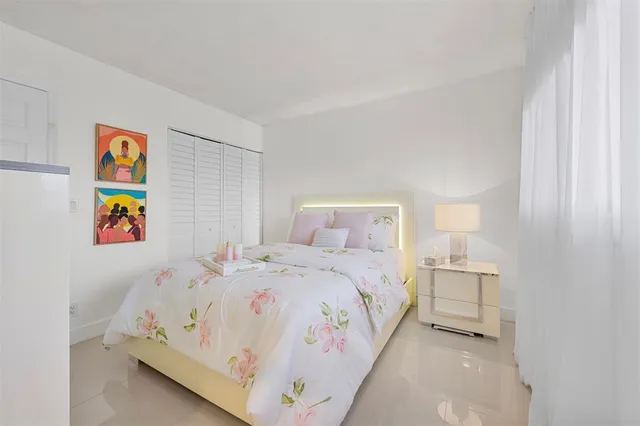 a bedroom with a bed and painting on the wall