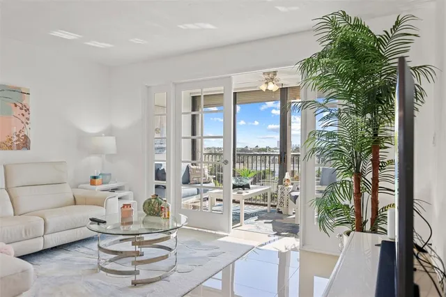 a living room with furniture and a large window with potted plants
