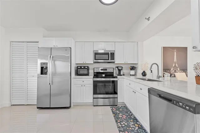 a kitchen with stainless steel appliances a refrigerator sink and microwave