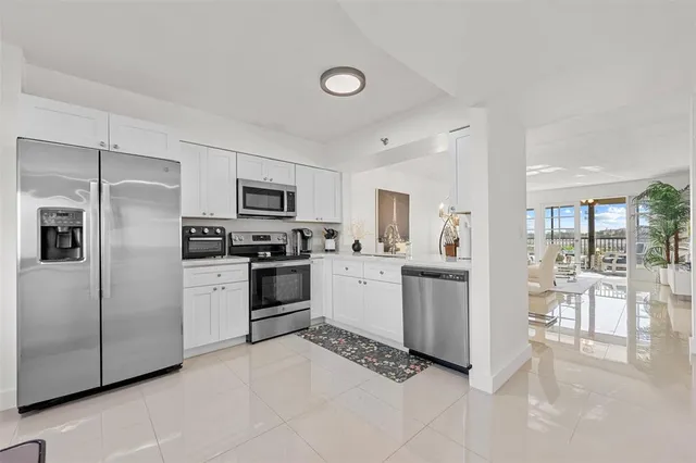 a kitchen with white cabinets and stainless steel appliances