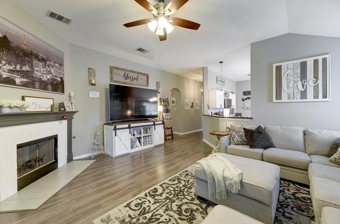 1307 Ridgewood Drive Leander, TX 78641 - Photo 3 of 16 a living room with furniture a flat screen tv and a fireplace