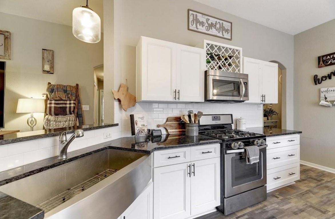 1307 Ridgewood Drive Leander, TX 78641 - Photo 5 of 16 a kitchen with granite countertop a sink cabinets and stainless steel appliances