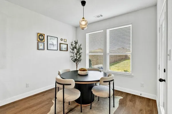 a dining room with furniture a window and wooden floor