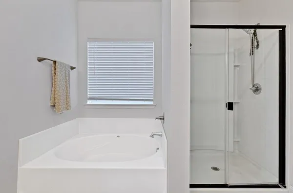 a white bath tub sitting next to a shower