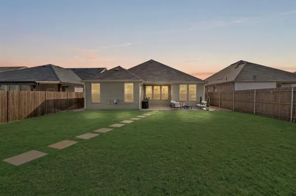 a front view of a house with a garden and yard