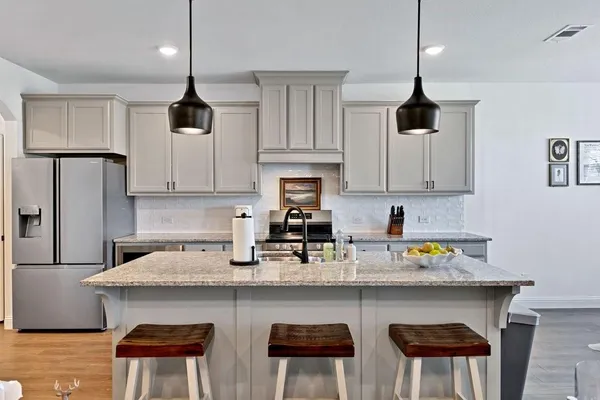 a kitchen with stainless steel appliances a sink a stove a refrigerator and cabinets