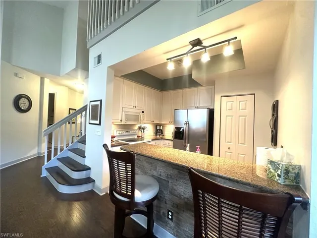 a kitchen with counter and chairs