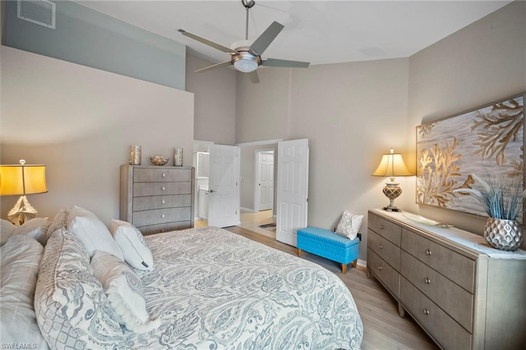 20051 Seagrove Street, Unit 1207 Estero, FL 33928 - Photo 19 of 32 a bedroom with a bed and a chandelier