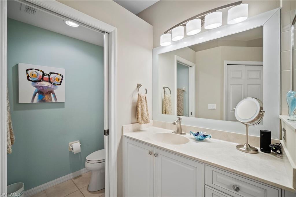 20051 Seagrove Street, Unit 1207 Estero, FL 33928 - Photo 23 of 32 a bathroom with a toilet a sink and mirror