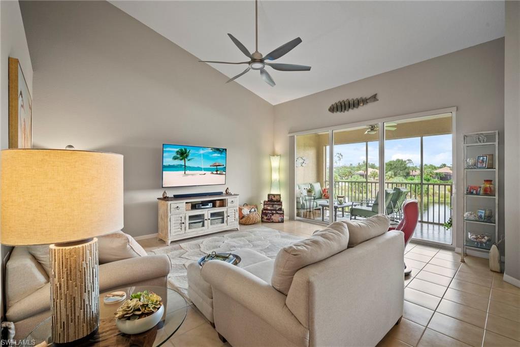 20051 Seagrove Street, Unit 1207 Estero, FL 33928 - Photo 8 of 32 a living room with furniture a flat screen tv and a large window