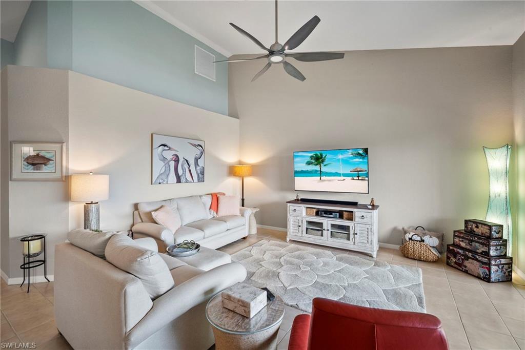 20051 Seagrove Street, Unit 1207 Estero, FL 33928 - Photo 9 of 32 a living room with furniture a flat screen tv and a fireplace