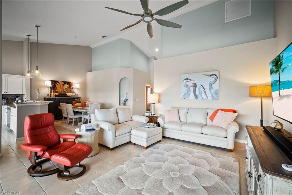 20051 Seagrove Street, Unit 1207 Estero, FL 33928 - Photo 10 of 32 a living room with furniture gym equipment and a chandelier