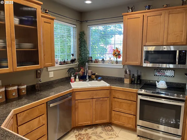 a room with lots of potted plants and open kitchen view