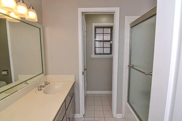 an empty room with windows and ceiling fan