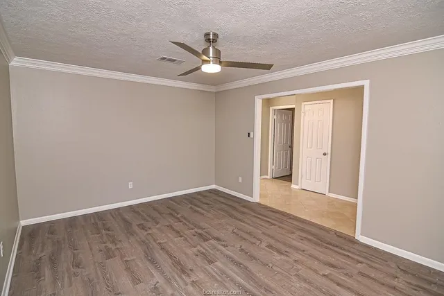 a view of an empty room with wooden floor