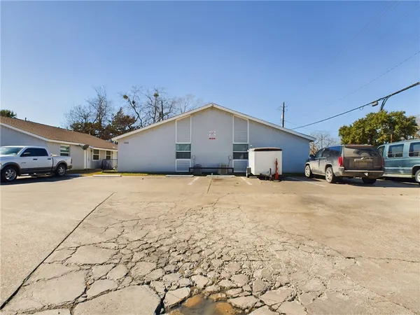a yellow house with a yard and parking space
