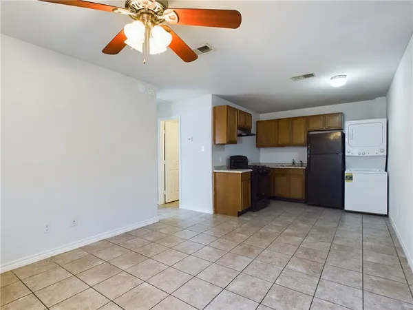 a kitchen with a refrigerator and a stove top oven