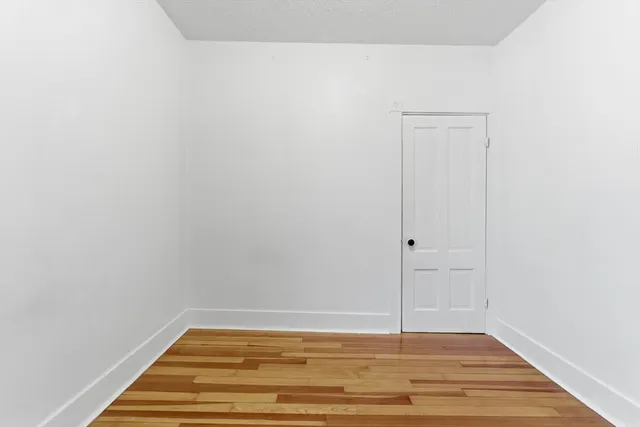 a view of a room with wooden floor and white walls