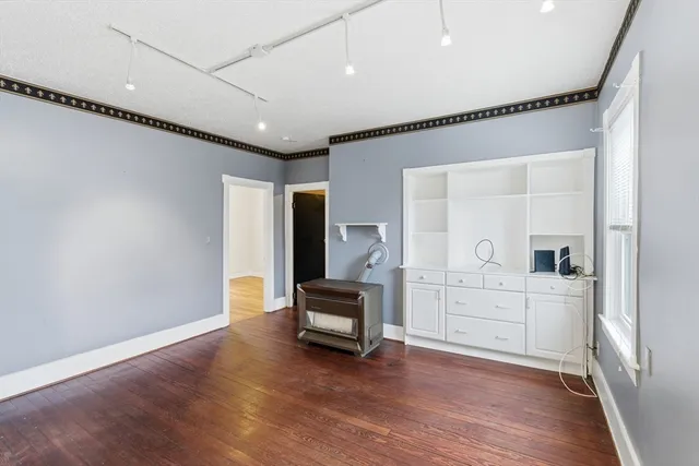 a hallway with a chair and wooden floor